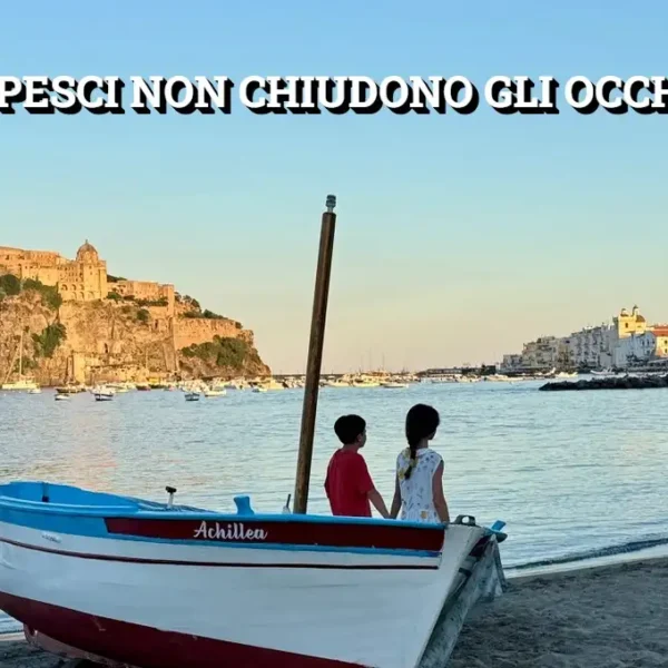 Due bambini guardano il mare di Ischia seduti su una barca chiamata Achillea, con il Castello Aragonese sullo sfondo