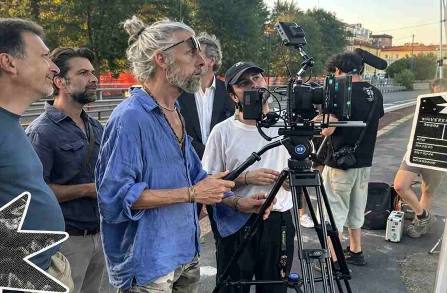 Troupe cinematografica al lavoro sul set del film Gelato al cioccolato a Milano con cinepresa su cavalletto e ciak in primo