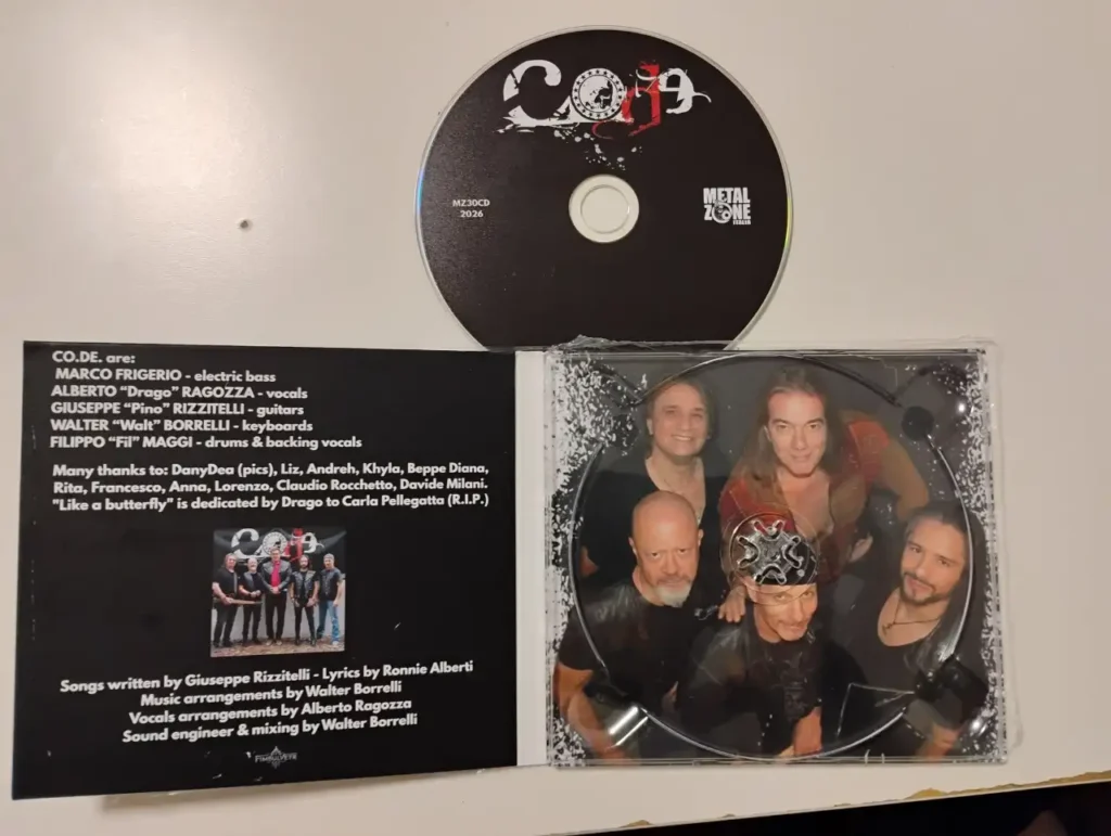 Il CD della band CO. DE. con la custodia aperta che mostra la foto dei componenti e i crediti dell'album su sfondo nero