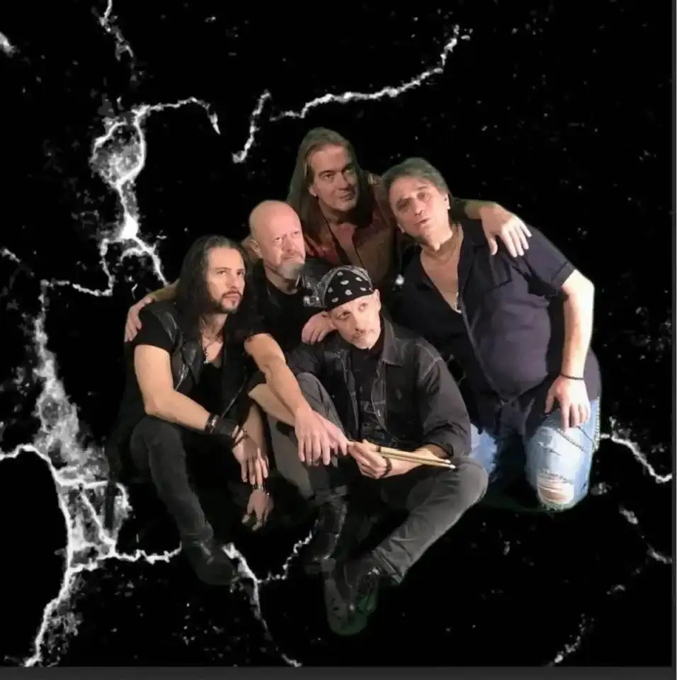 I cinque componenti della co. de band posano insieme su uno sfondo nero con venature bianche simili a fulmini