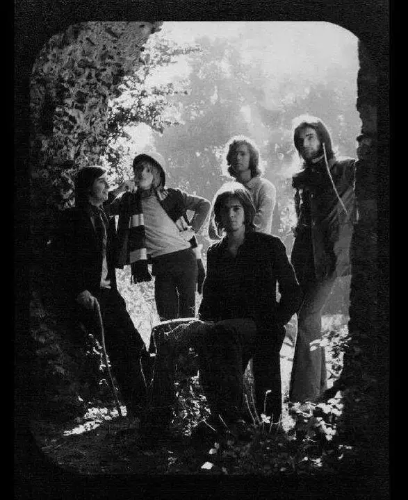 I membri del gruppo Genesis posano in bianco e nero tra le rovine di un edificio in una foto promozionale d'epoca