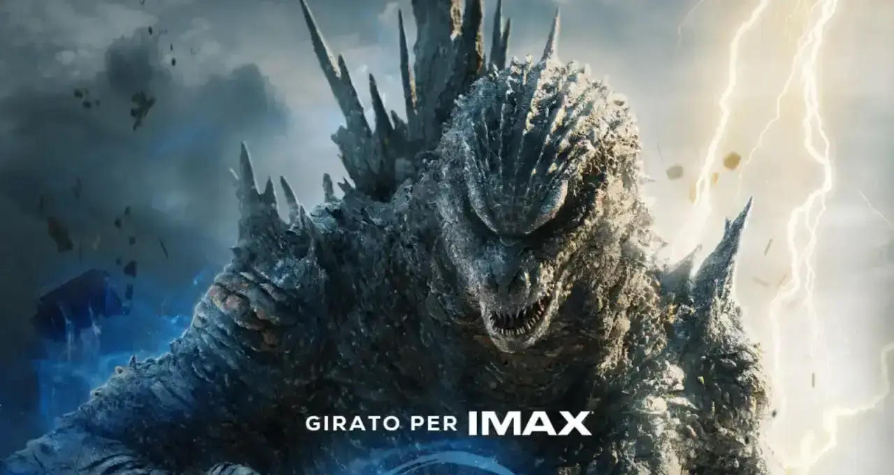 Godzilla in primo piano con pelle squamosa scura, creste dorsali appuntite e artigli, fulmini sullo sfondo e scritta "GIRATO