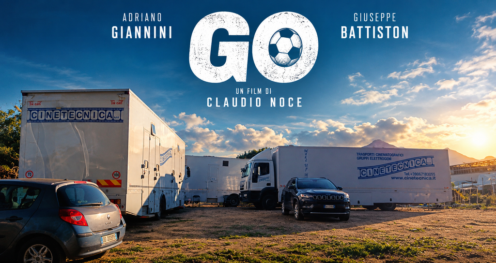 Camion della Cinetecnica e auto parcheggiati in un campo al tramonto per le riprese del film Go di Claudio Noce