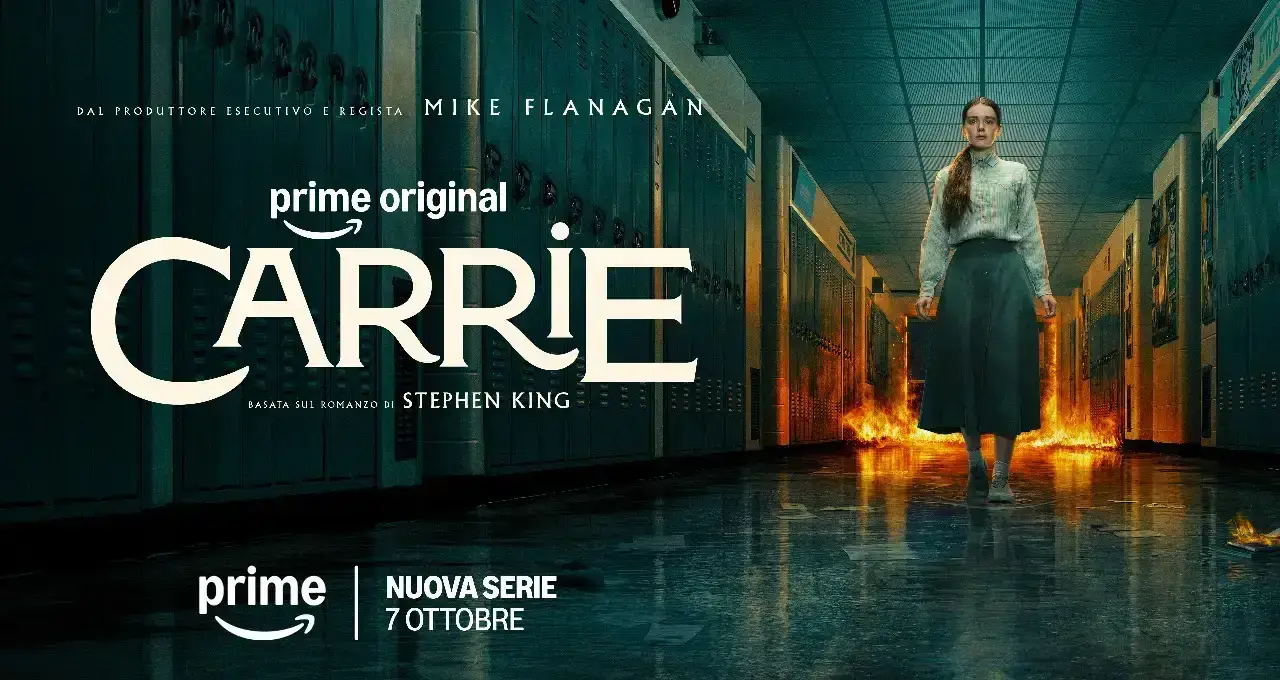 Carrie in piedi in corridoio scolastico con armadietti verdi, fiamme sul pavimento dietro di lei e grande scritta CARRIE e