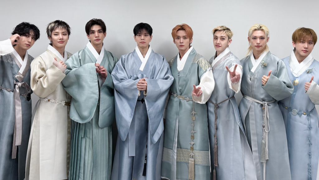 Stray Kids schierati in kimono tradizionali dai toni azzurro e grigio, in posa frontale con mani giunte o segni di vittoria