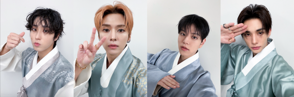 Quattro membri degli Stray Kids in hanbok verde-azzurro chiaro su sfondo bianco, in pose che mostrano gesti con le mani e