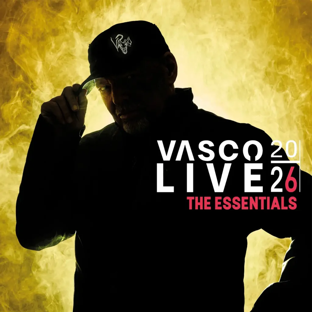 Vasco Rossi indossa un cappellino con logo su sfondo giallo fumo, accanto alla scritta Vasco Live 20|26 – The Essentials