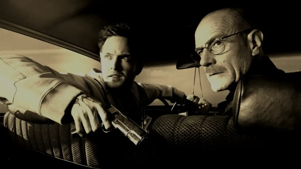 Walter White e Jesse Pinkman in auto, con Jesse che impugna una pistola, in una scena drammatica di Breaking Bad