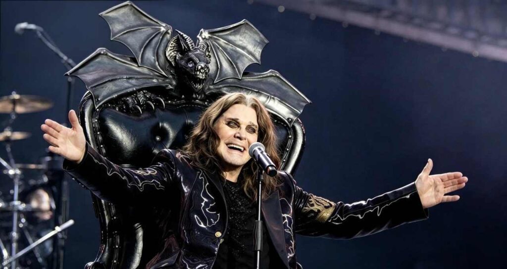 Ozzy Osbourne seduto su un trono nero con pipistrello decorativo dietro, microfono davanti e braccia aperte sul palco