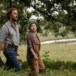 Matthew McConaughey cammina in un campo con una ragazza in una scena del film La ballata del re delle api