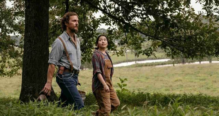 Matthew McConaughey cammina in un campo con una ragazza in una scena del film La ballata del re delle api