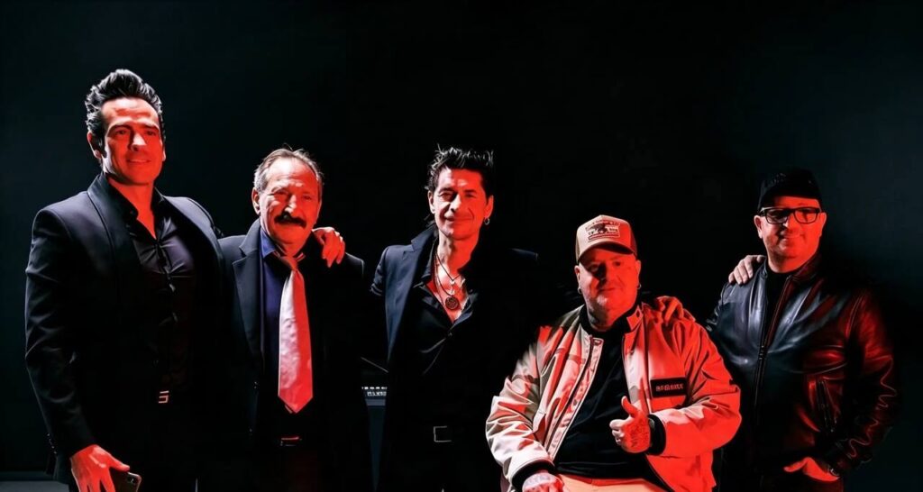 I MotelNoire posano insieme in una foto promozionale per il loro concerto milano, illuminati da una luce rossa su sfondo