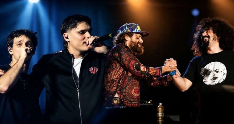 Quattro musicisti sul palco, tra cui il rapper Geolier, si esibiscono cantando e stringendosi la mano durante un concerto