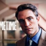 Robert Pattinson in primo piano con giacca beige e camicia azzurra accanto alla scritta Primetime del nuovo thriller A24