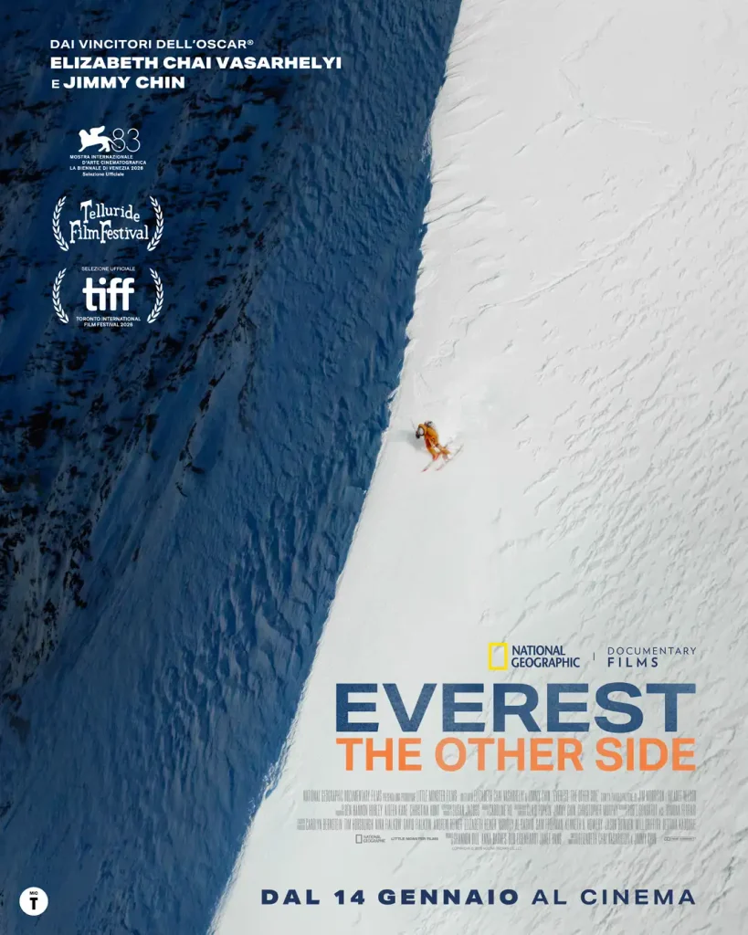 Poster verticale con scialpinista in tuta arancione che scende un pendio nevoso bianco a fianco di un muro di roccia scura