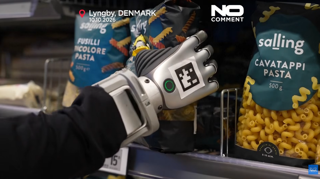 Una mano robotica con un codice QR sul dorso afferra una confezione di pasta Salling in un supermercato danese