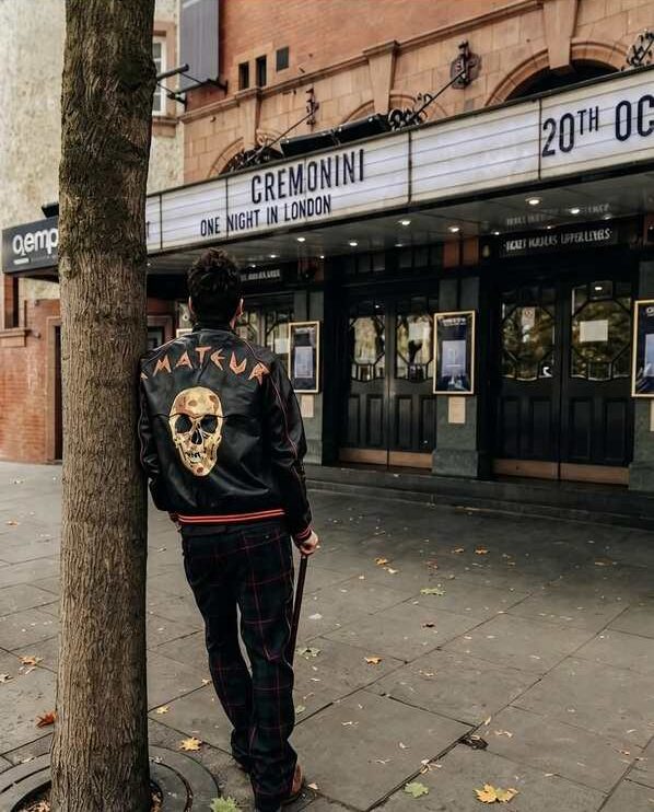 Cesare Cremonini di spalle indossa un giubbotto con la scritta Amateur davanti al cinema di Londra per il suo live