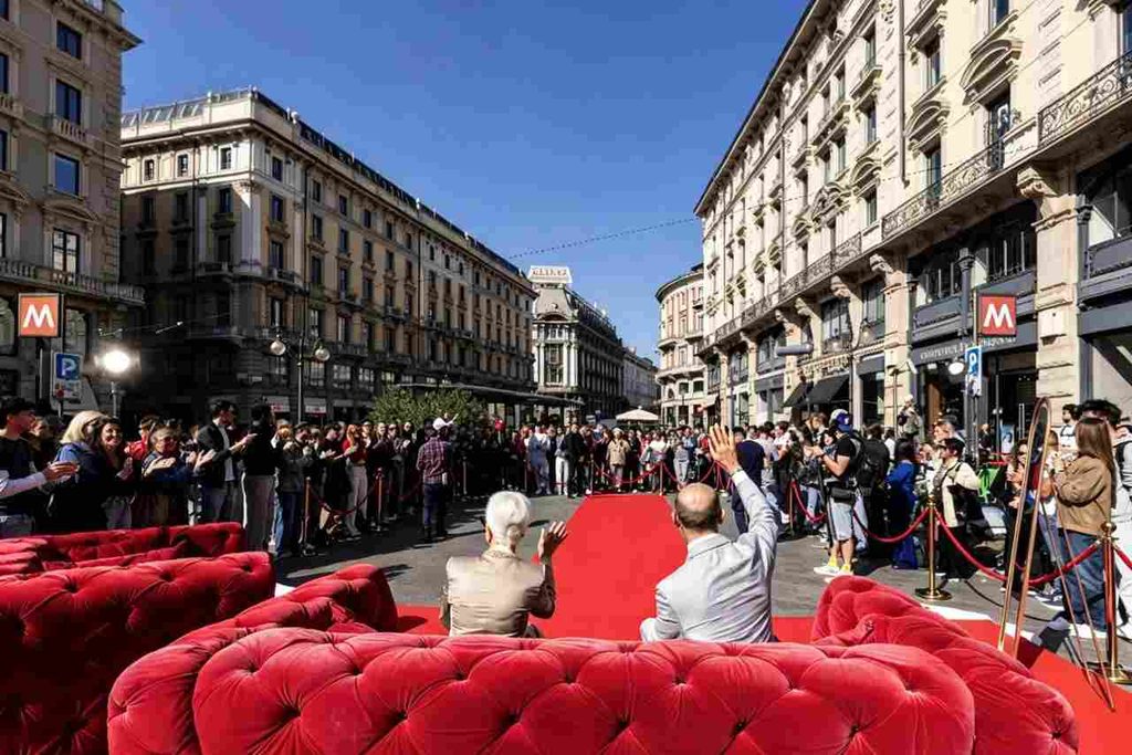 Enzo Miccio e Carla Gozzi seduti su un divano rosso in Piazza Cordusio per il ma come ti vesti celebration di Real Time