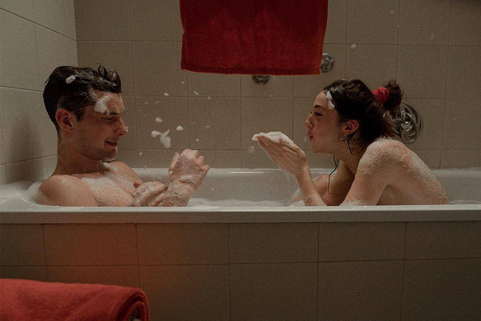 Una coppia gioca con la schiuma in una vasca da bagno in una scena tratta dal film La città dei vivi
