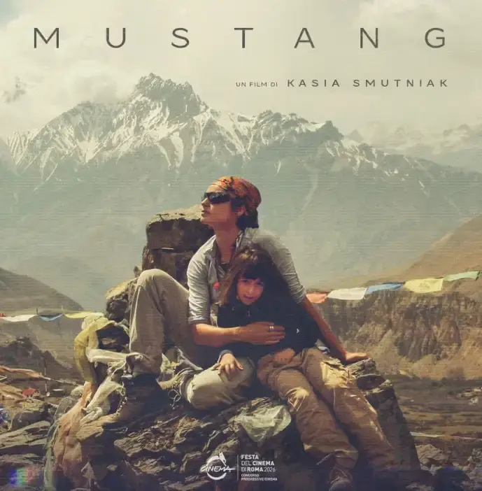 Kasia Smutniak abbraccia una bambina seduta su una roccia davanti alle montagne del Mustang nel documentario Mustang